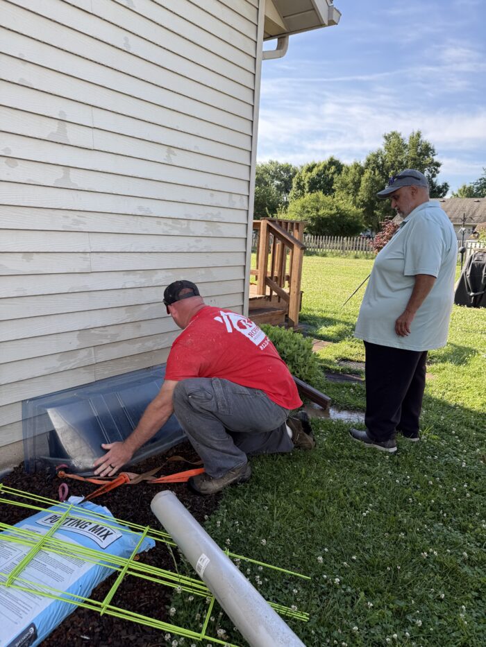 Roehm Team outside with homeowner accessing the crawl space of the home.