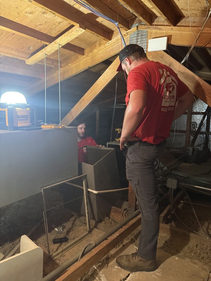 Roehm Team members in attic working on duct work.